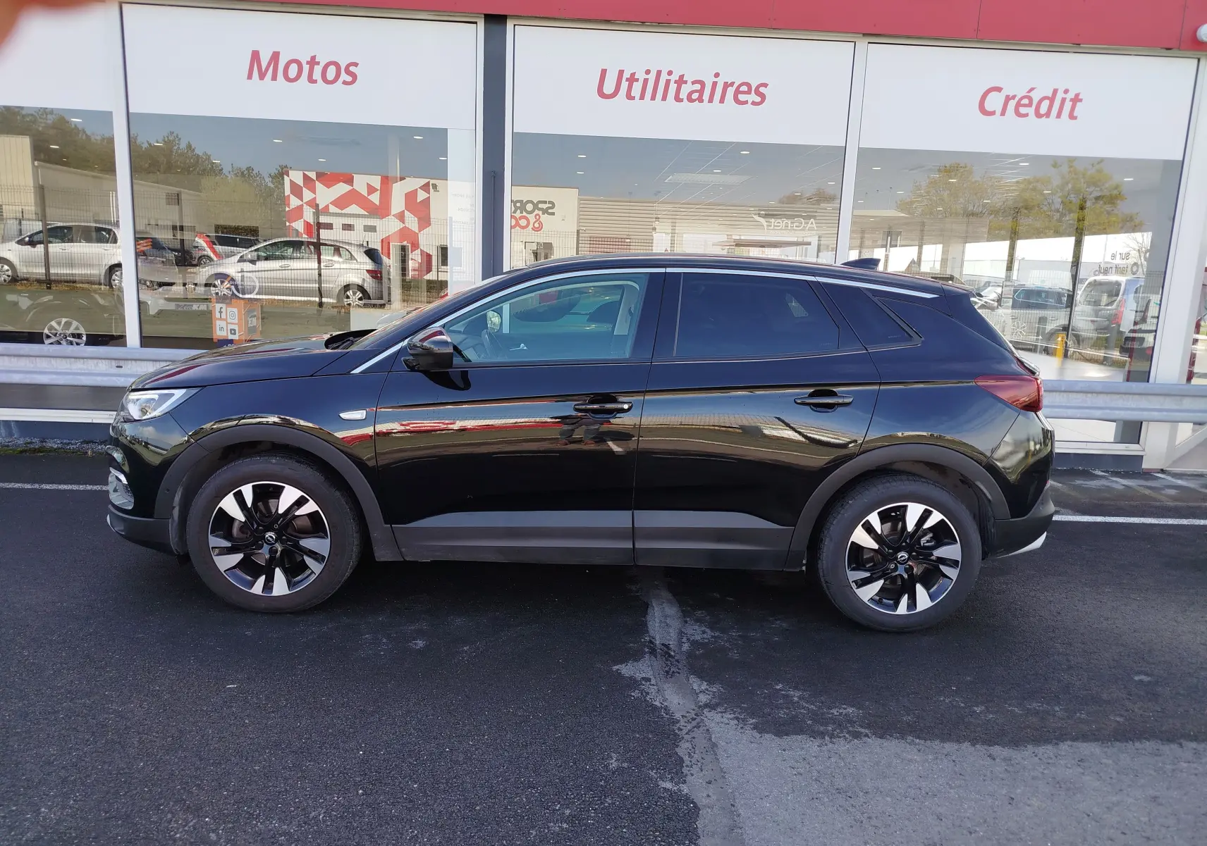 Vue de profil côté gauche d’un Opel Grandland X noir diamant 2021 avec jantes bicolores et détails noirs satinés.