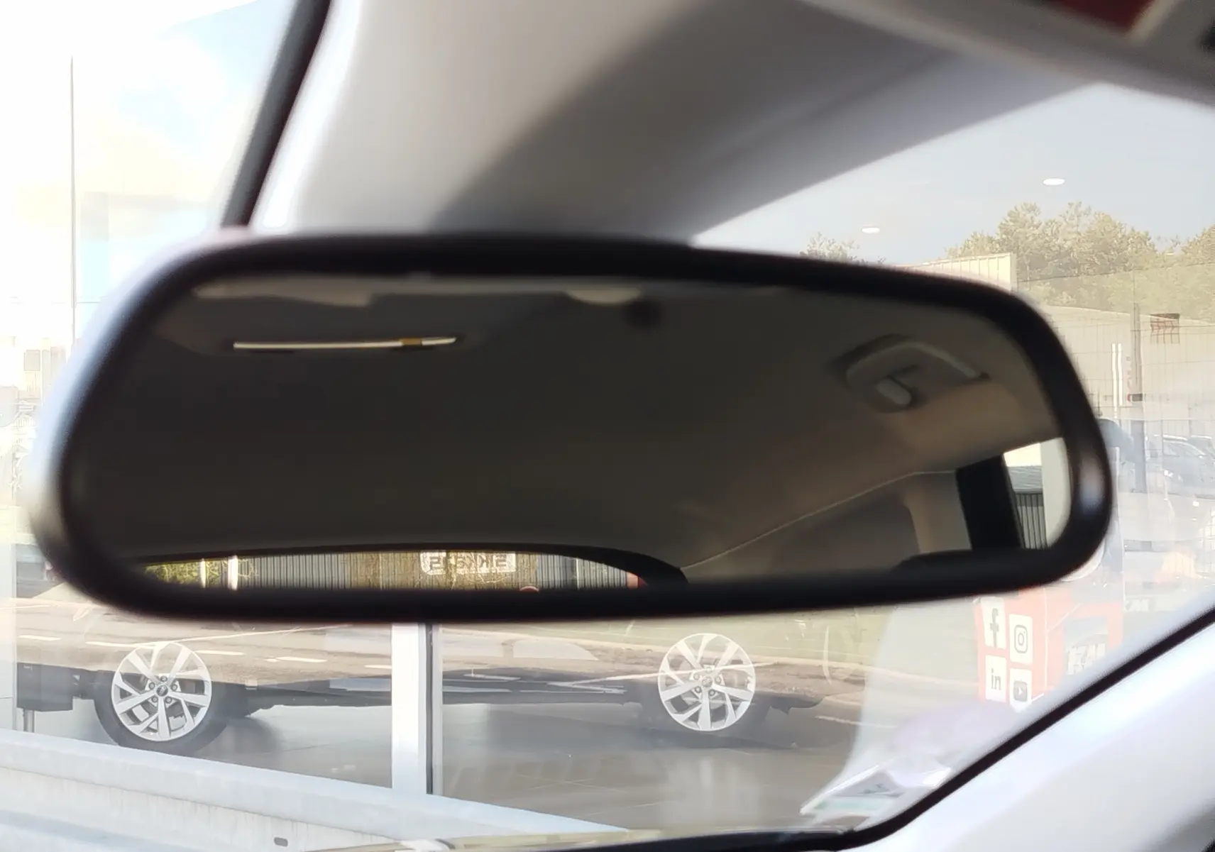 Rétroviseur intérieur montrant le reflet d'un Opel Grandland X noir Diamant garé à l'extérieur, vue latérale droite.