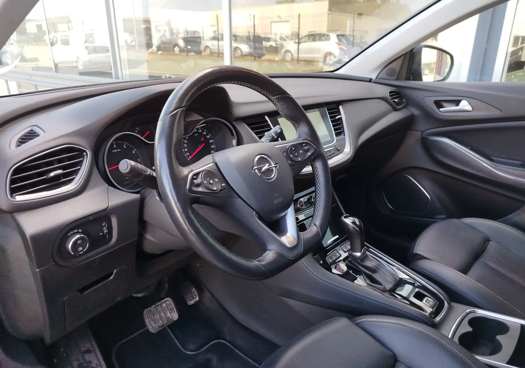 Vue intérieure côté conducteur de l'Opel Grandland X 2021, volant cuir noir et console centrale avec boîte automatique.
