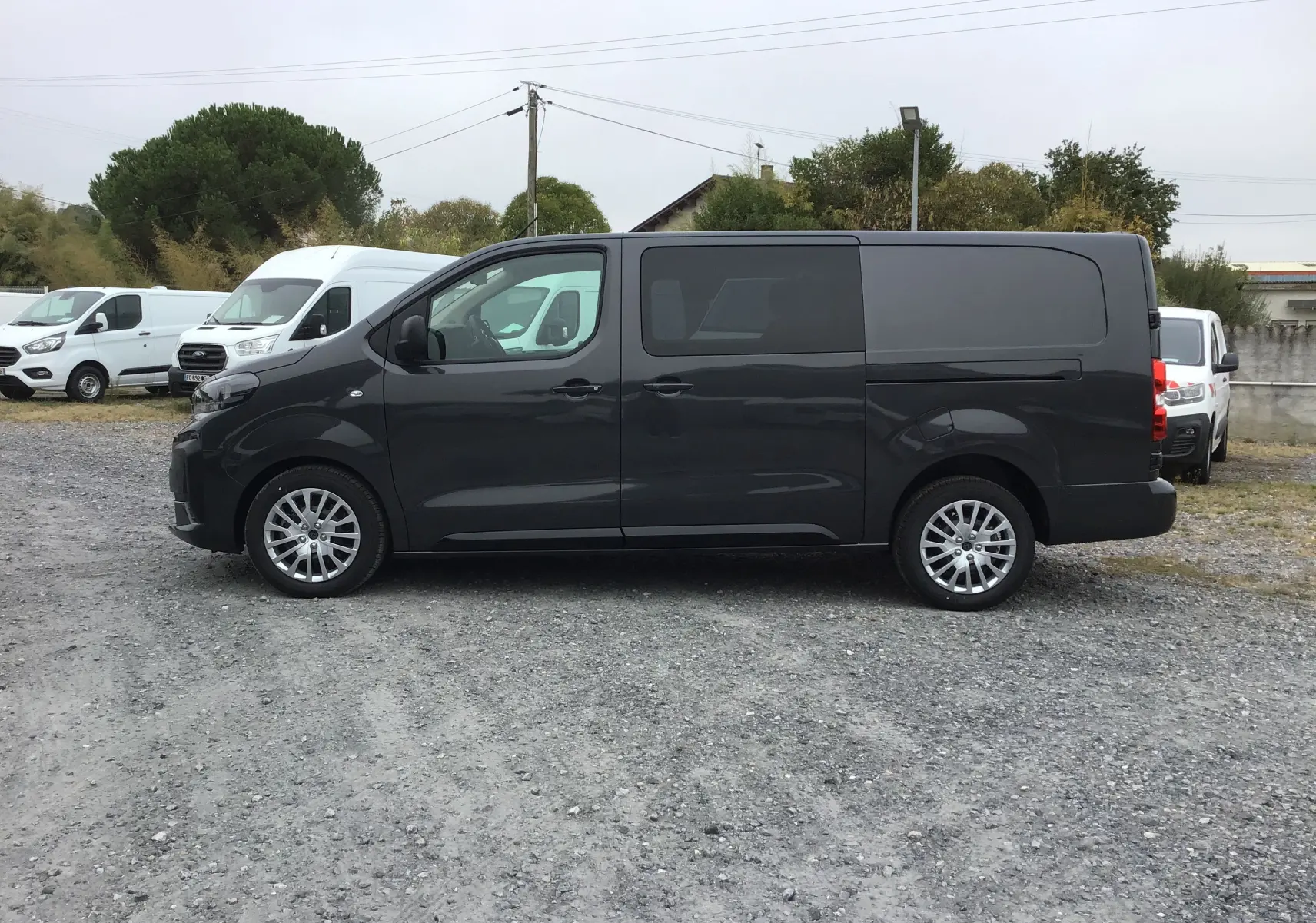 Vue de profil côté gauche d’un Peugeot Expert Cabine Approfondie gris titane, avec jantes alliage et fenêtres teintées.
