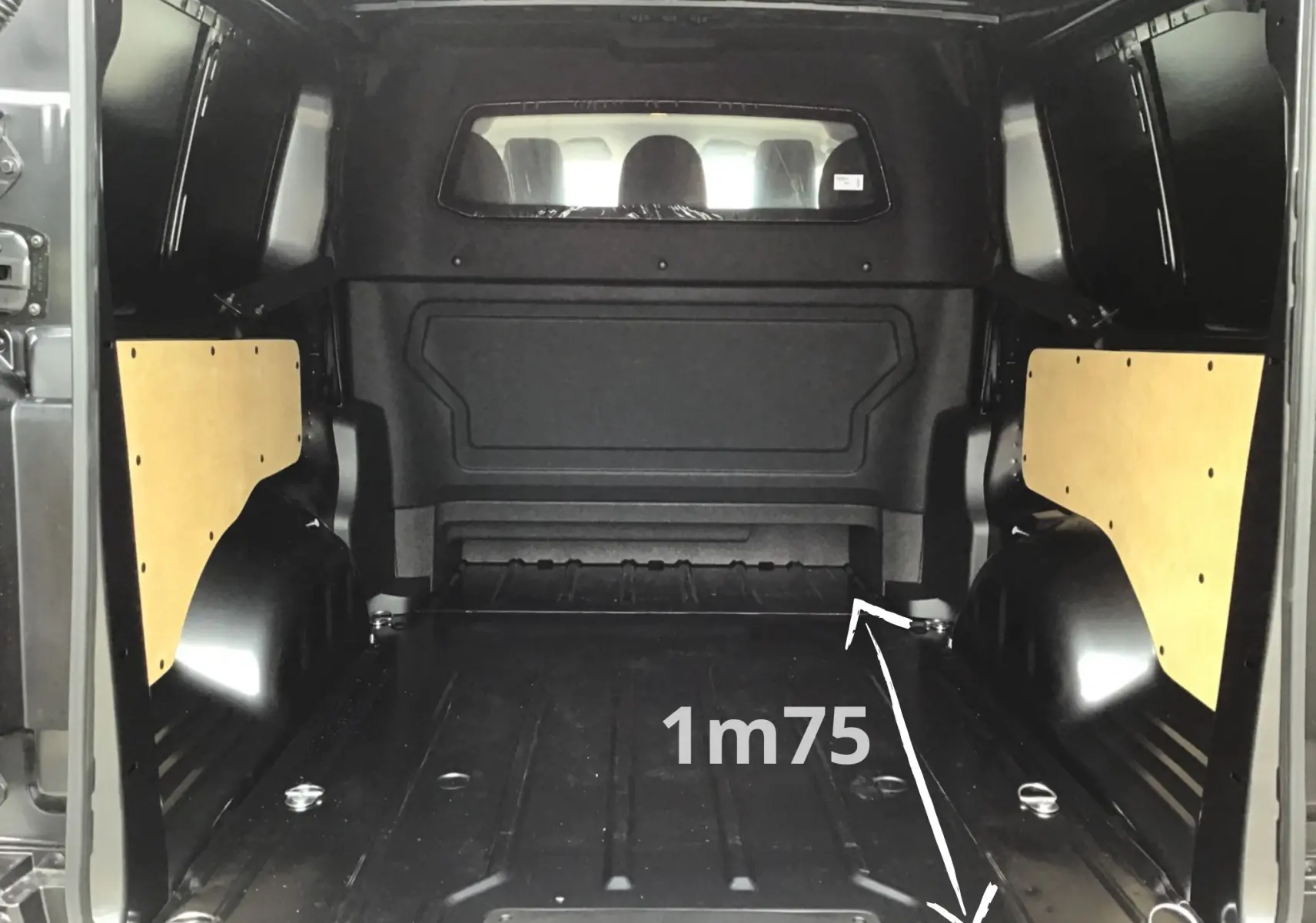 Vue intérieure arrière du Peugeot Expert XL gris titane, montrant l’espace de chargement avec panneaux latéraux en bois clair.