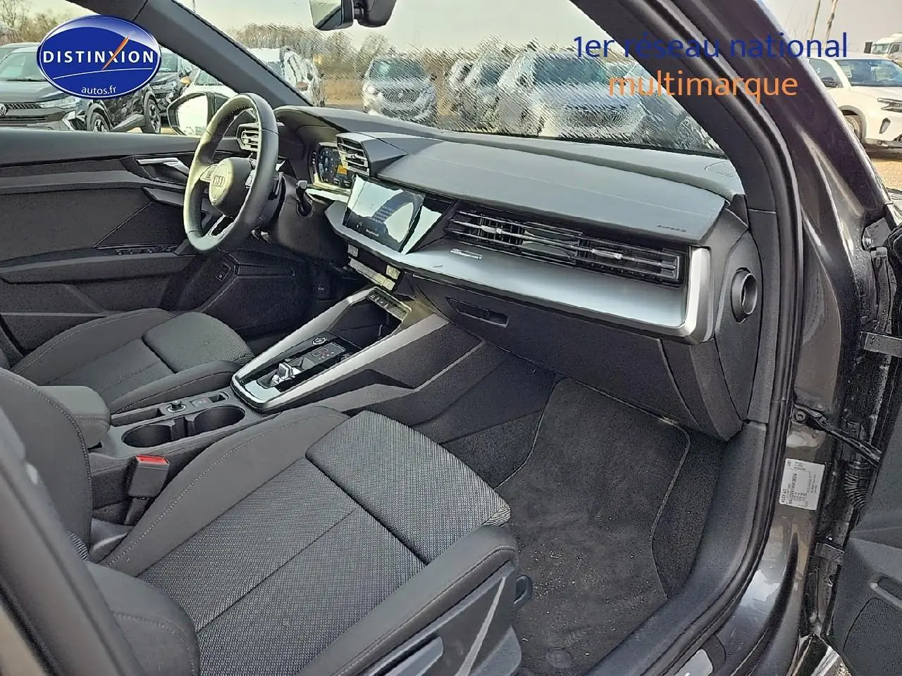 Intérieur avant droit de l'Audi A3 Sportback 45 TFSI e 2024 gris Daytona avec tableau de bord moderne et sièges sport noirs.