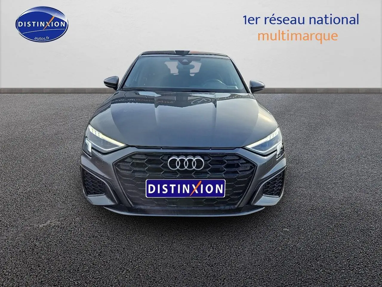 Vue avant d'une Audi A3 Sportback 45 TFSI e 245 S line gris Daytona avec calandre noire et phares LED allumés.