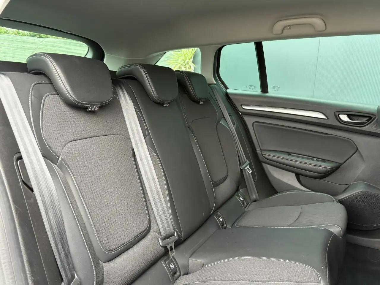 Vue latérale droite de la banquette arrière noire en similicuir et tissu de la Renault Mégane Break 2024.