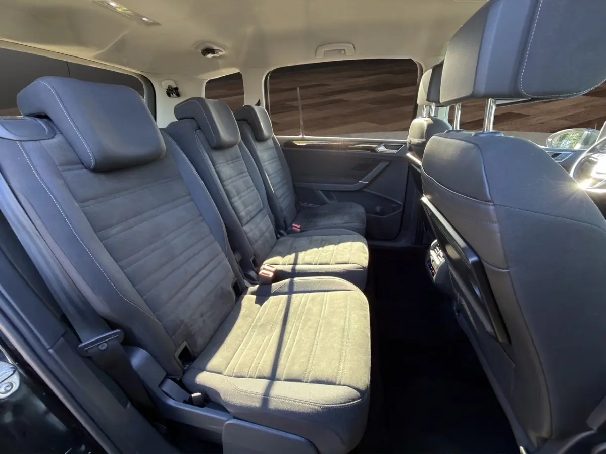 Vue intérieure côté gauche des sièges arrière noirs du Volkswagen Touran 1.6 TDI 7 places de 2016.