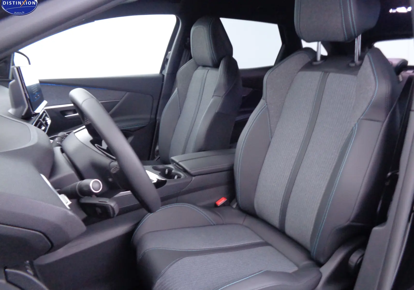 Intérieur du Peugeot 3008 2023 vu côté conducteur, sièges en tissu gris et cuir noir avec surpiqûres bleues.