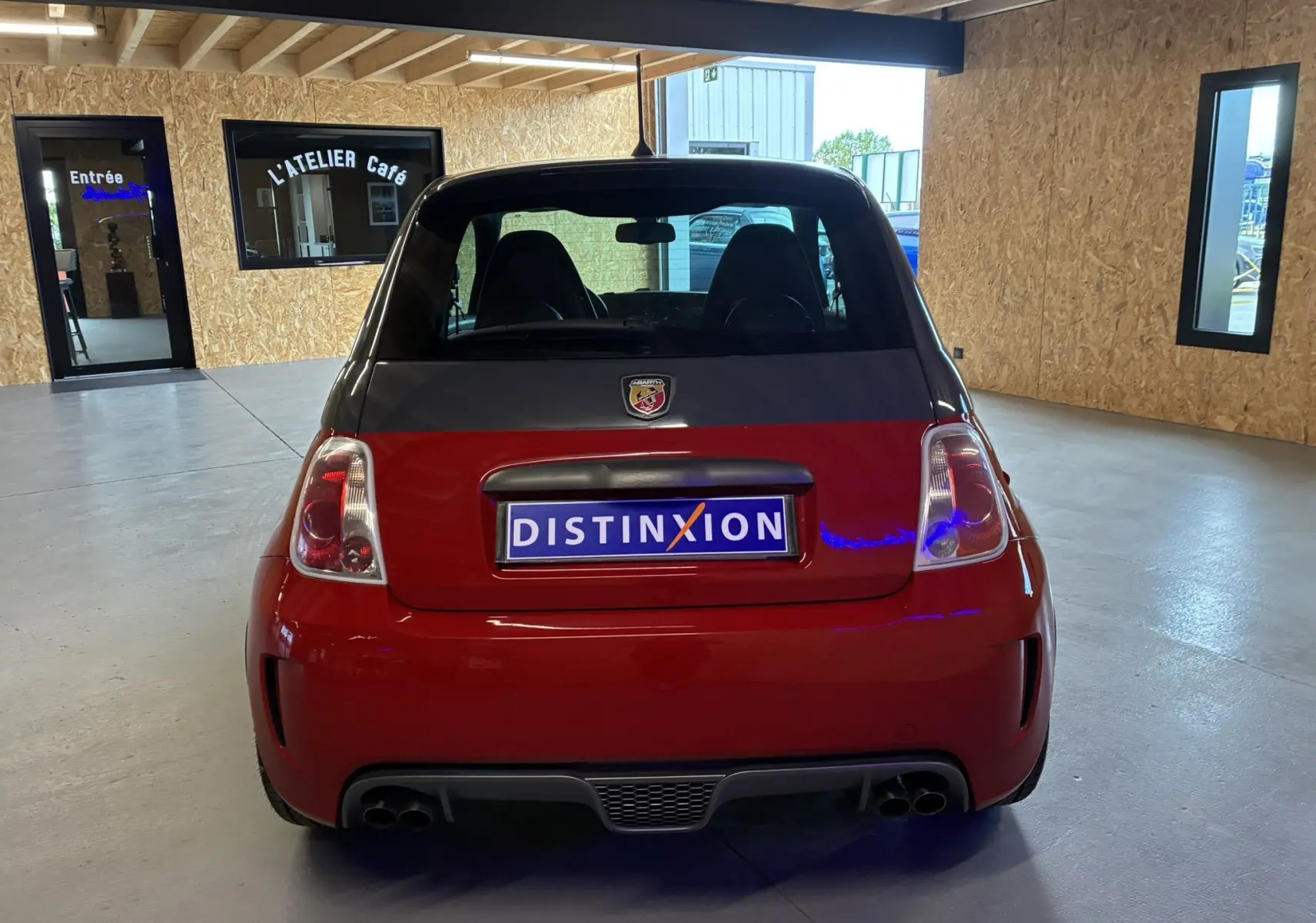 Vue arrière d'une ABARTH 500 rouge 2016 avec double sortie d'échappement et logo Abarth visible sur le hayon.