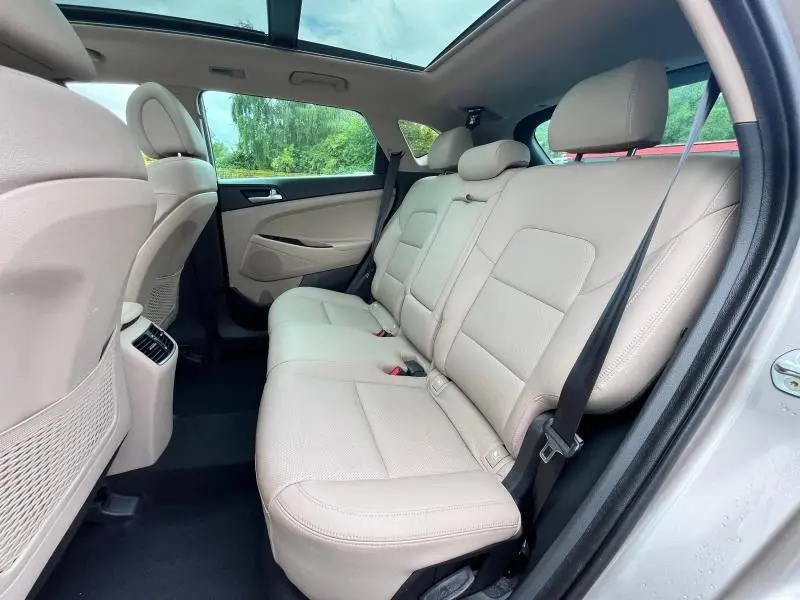 Vue intérieure côté droit des sièges arrière en cuir beige clair d'un Hyundai Tucson 2017 avec toit ouvrant panoramique.