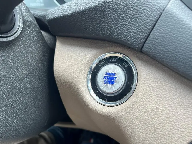 Bouton start/stop bleu sur fond beige du tableau de bord du Hyundai Tucson 2017 version Executive.