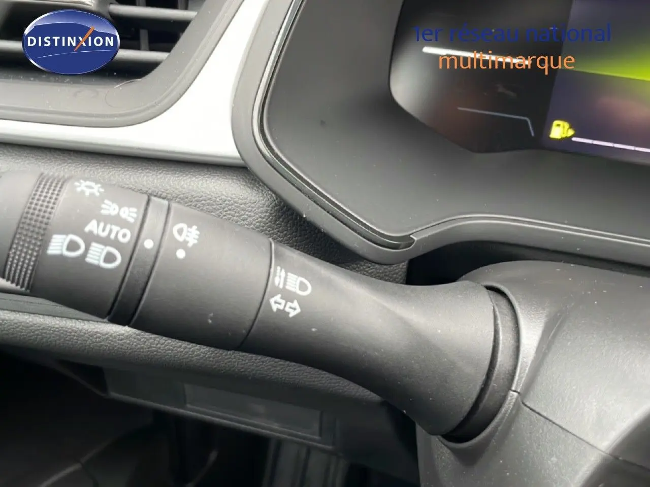 Gros plan sur la commande des phares et clignotants du tableau de bord du Renault Captur noir étoile métal 2025.