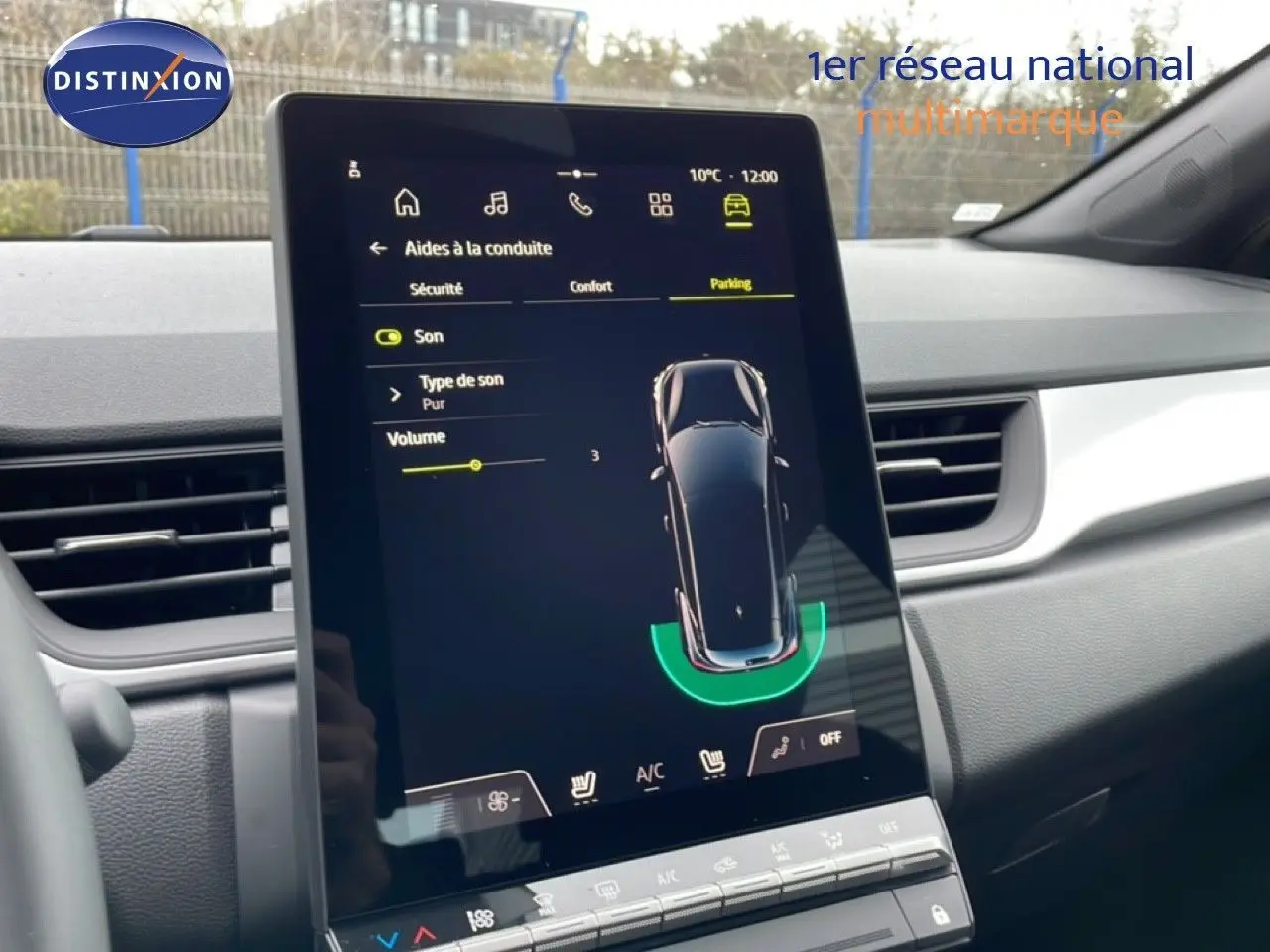 Vue intérieure centrée sur l'écran tactile du tableau de bord du Renault Captur noir étoile métal, affichant l'aide au stationnement.