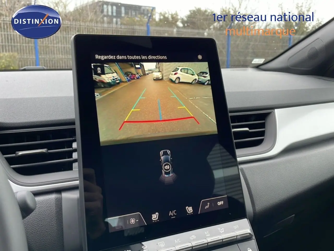 Vue intérieure du tableau de bord du Renault Captur 2025, écran tactile affichant la caméra de recul avec guidage coloré.