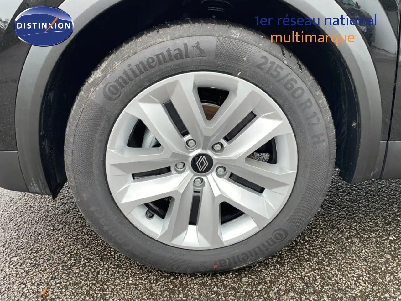 Gros plan sur la roue avant droite du Renault Captur noir étoile métal, mettant en valeur la jante argentée et le pneu Continental.