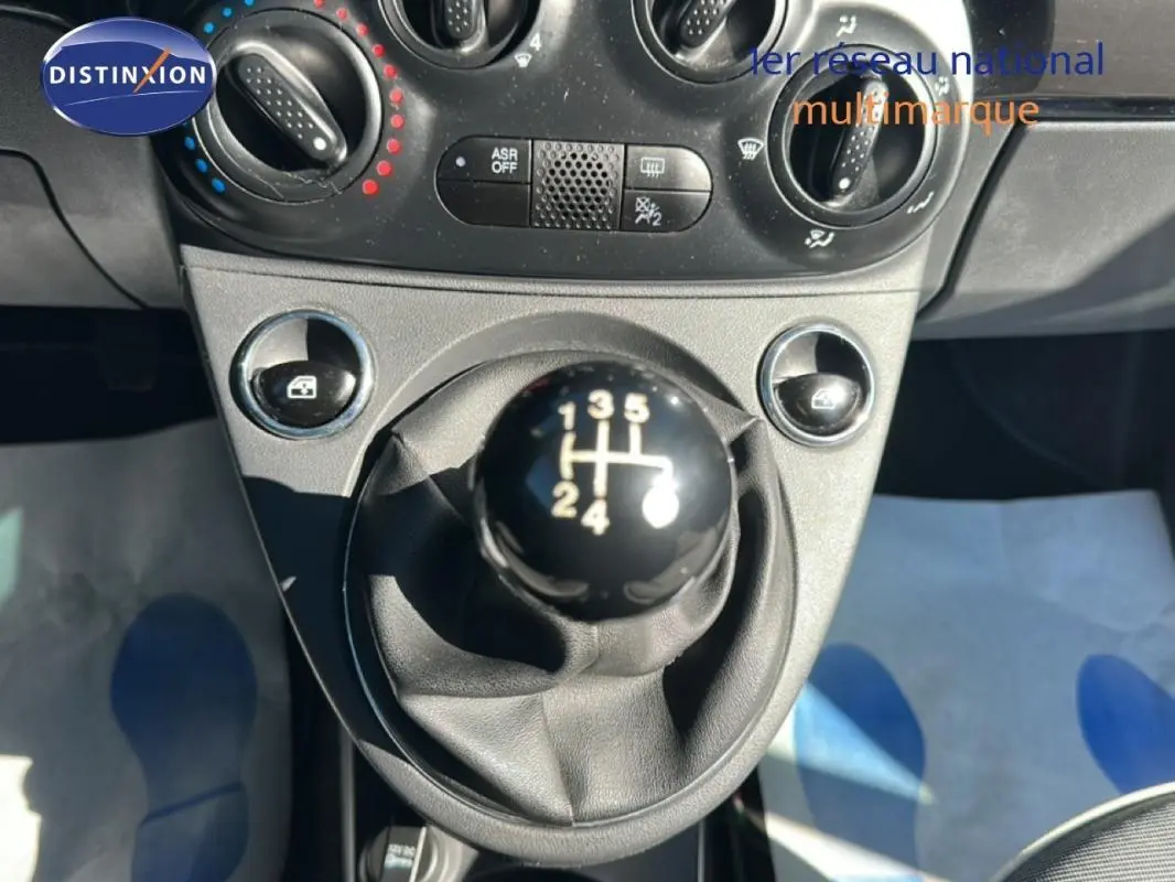 Le levier de vitesses manuel noir de la FIAT 500 Lounge 2016, avec commandes de climatisation en arrière-plan.