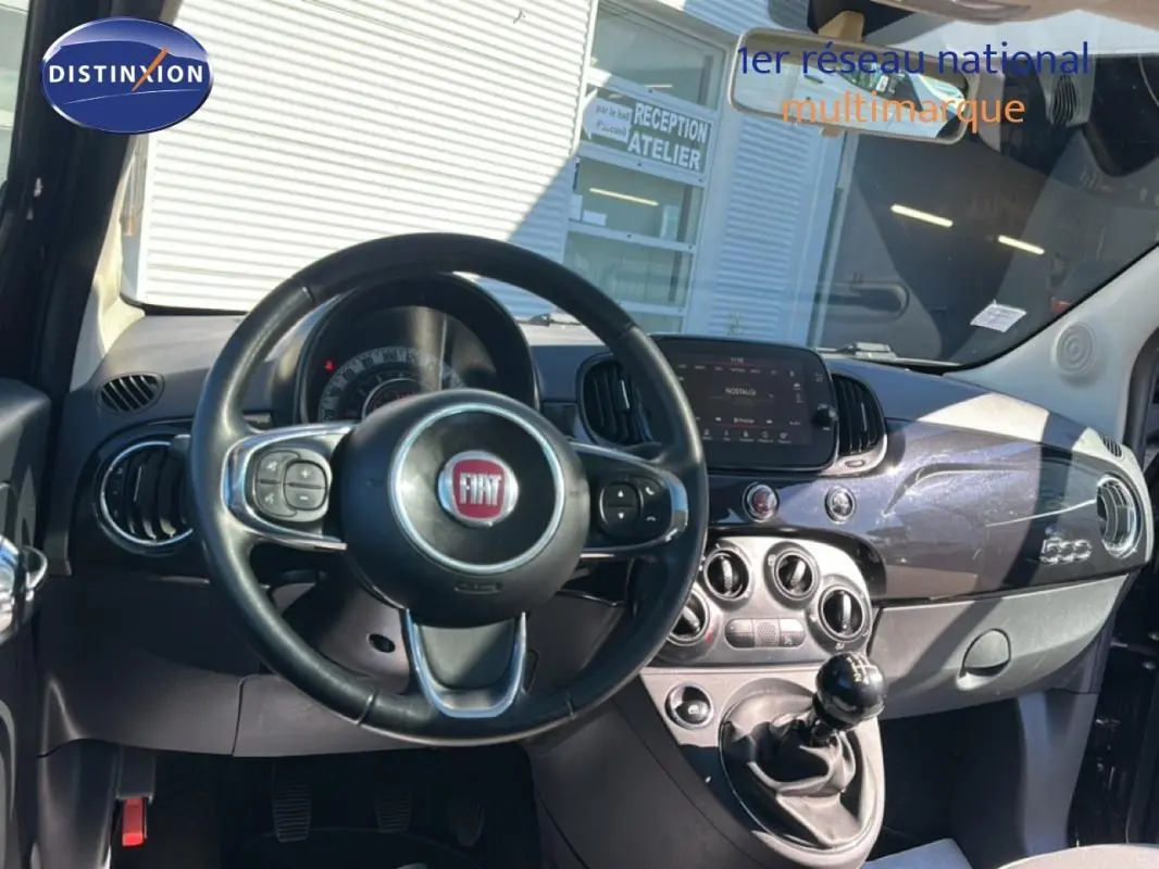 Vue intérieure avant du tableau de bord et volant noir de la Fiat 500 Lounge 2016 avec boîte manuelle et écran tactile central.