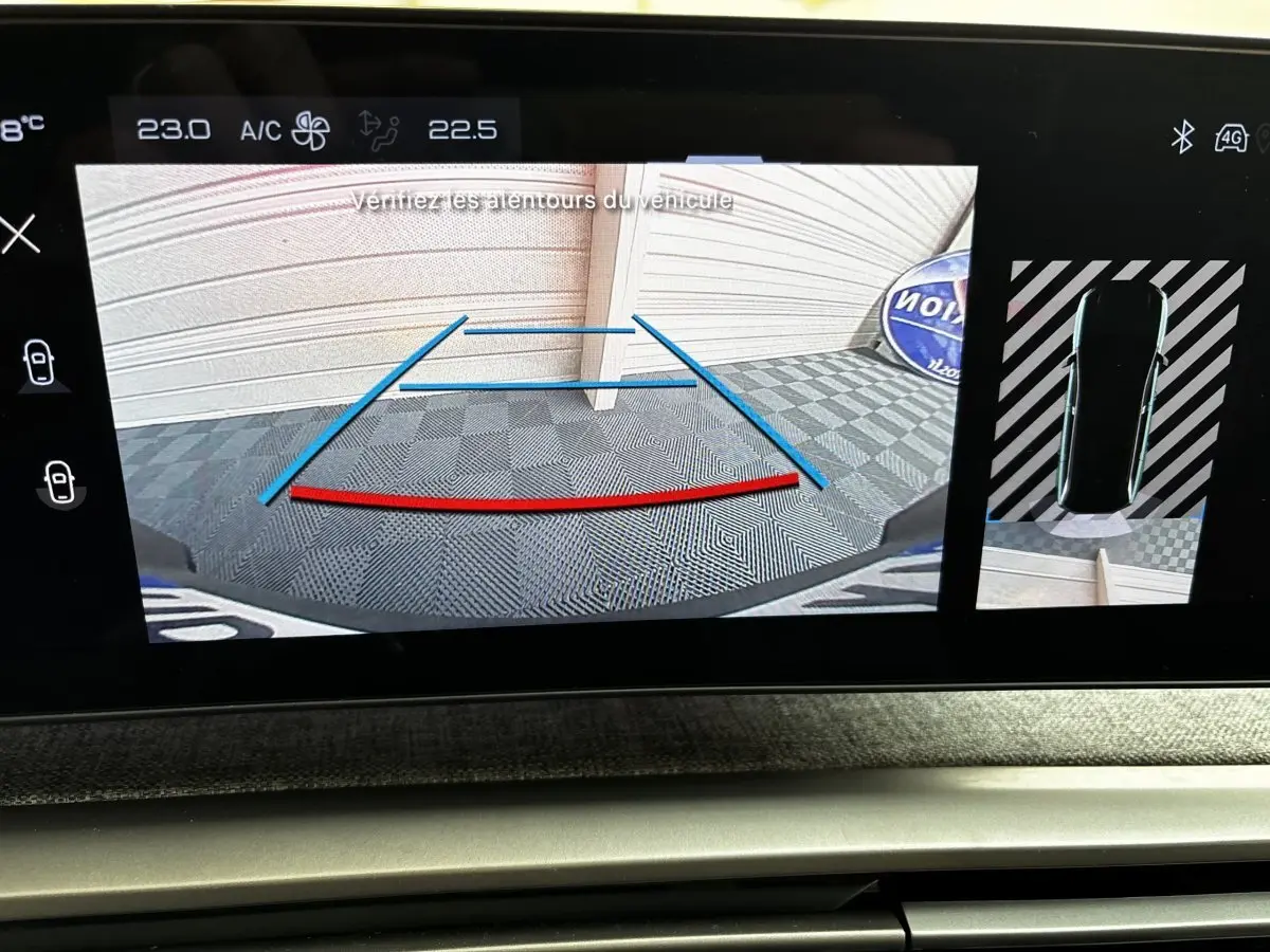 Affichage écran tactile intérieur montrant la caméra de recul et vue 360° du Peugeot 5008 gris clair 2025 en stationnement.