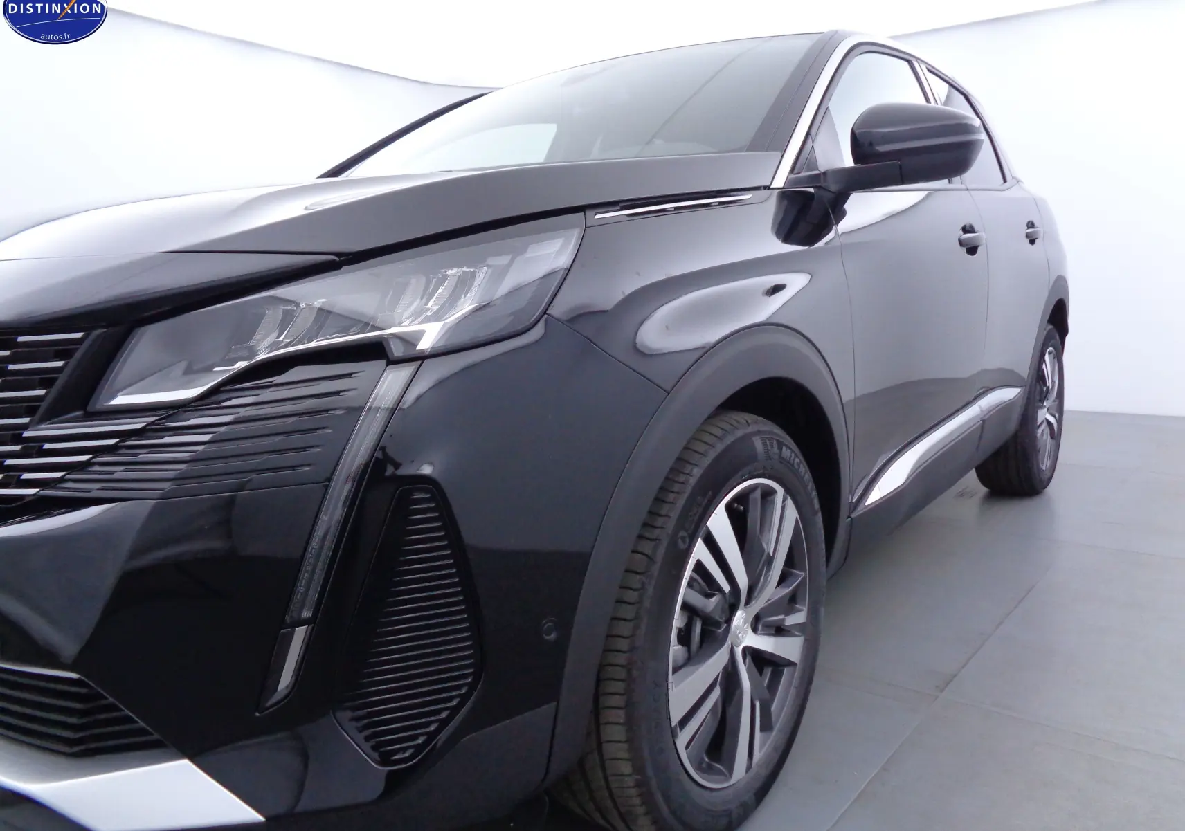 Vue 3/4 avant droit du Peugeot 3008 noir métal 2023 avec ses phares LED et jantes alliage biton.