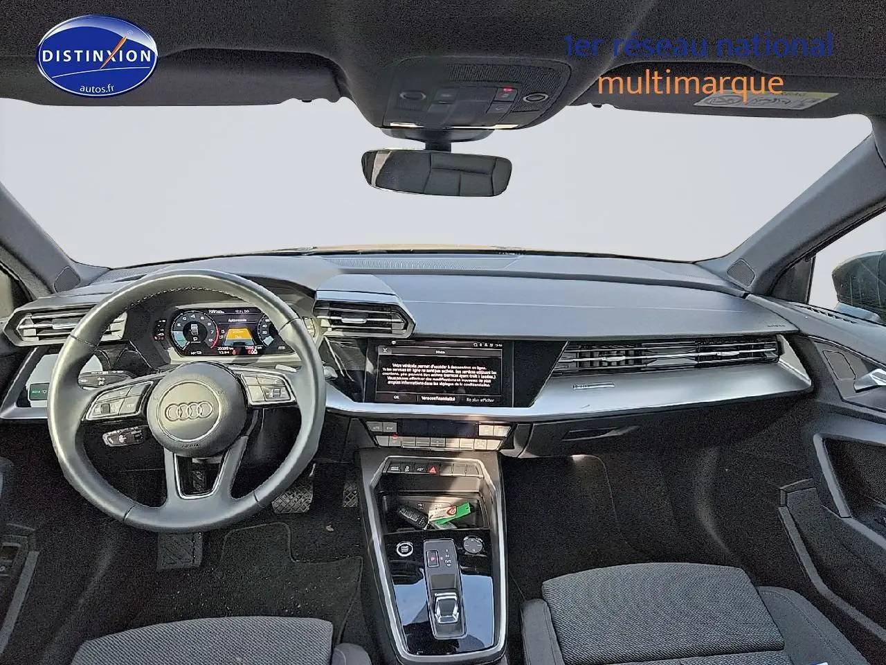 Vue intérieure avant de l'Audi A3 Sportback 2024, tableau de bord moderne avec écran tactile et volant cuir multifonction.