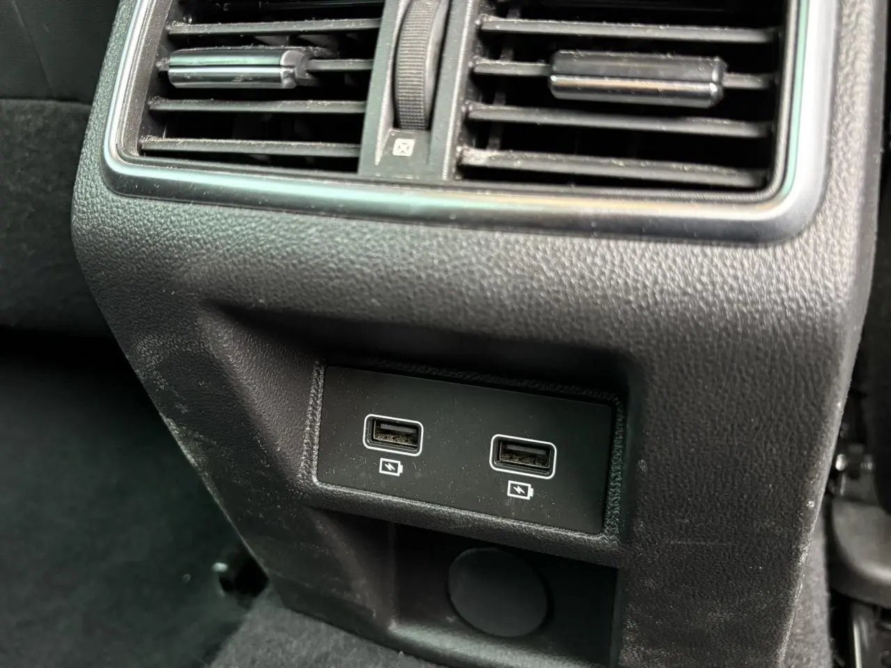 Prise USB double en gros plan sous la grille d'aération arrière d'une Renault Mégane Break gris Highland 2024.