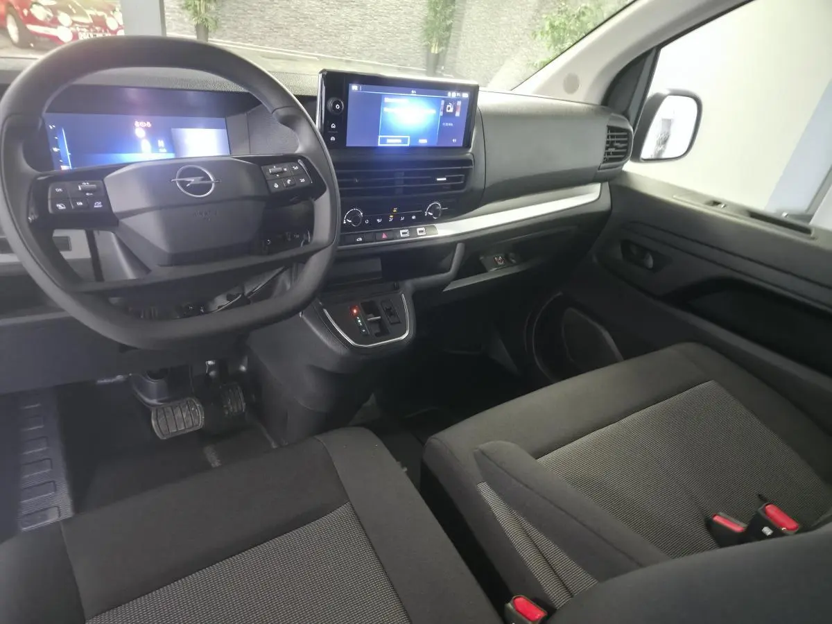 Vue intérieure avant droite de l’Opel Vivaro 2025 avec tableau de bord noir, écran tactile 10’’ et sellerie tissu bi-ton.