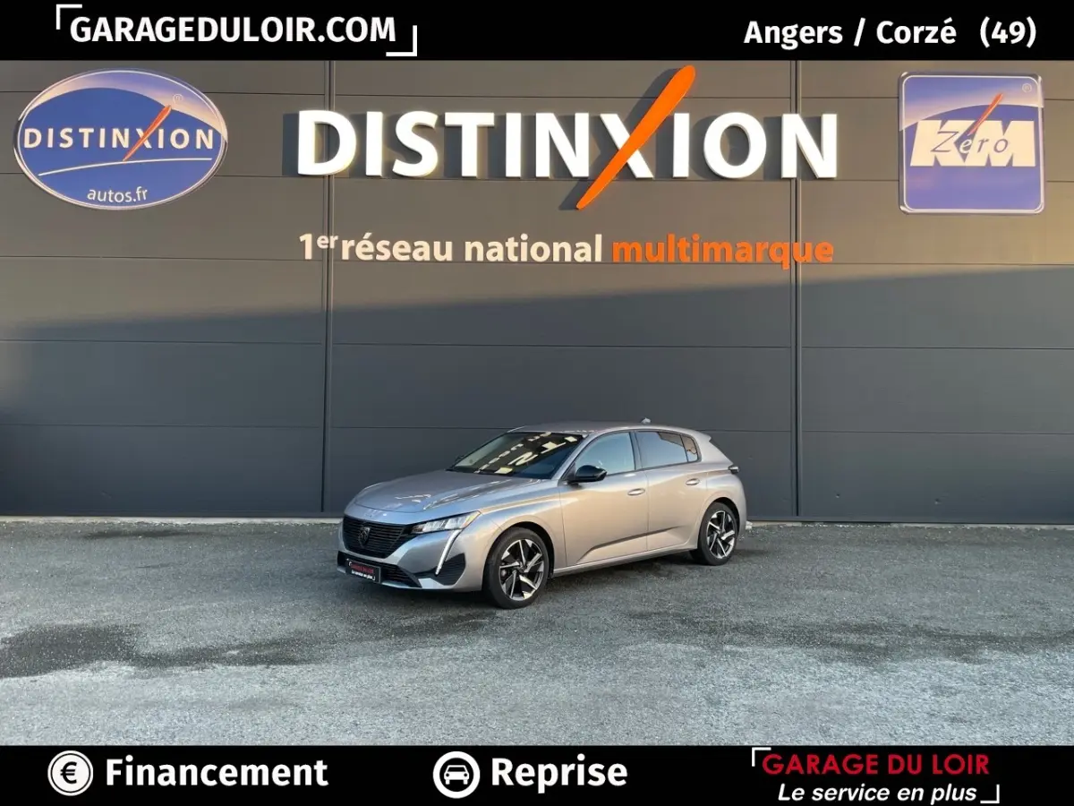 Peugeot 308 gris foncé vue en 3/4 avant droit devant un mur avec logo Distinxion.