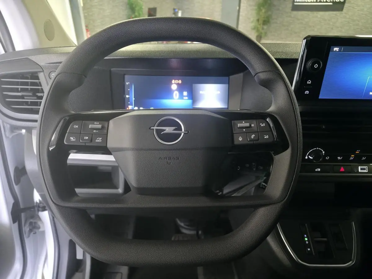 Vue frontale du volant noir de l'Opel Vivaro 2025 avec combiné numérique et écran tactile sur planche de bord noire.