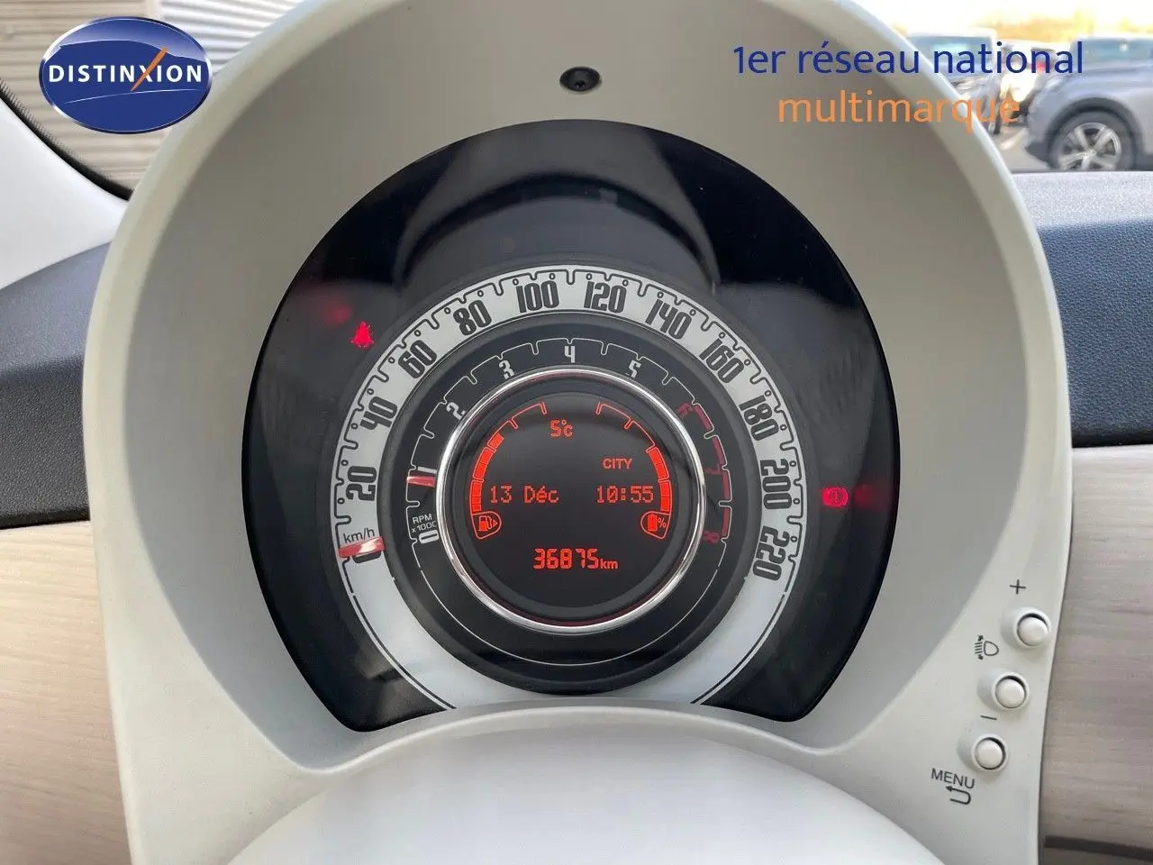 Vue rapprochée du tableau de bord de la Fiat 500 blanche, affichant le compteur digital et la vitesse en km/h.