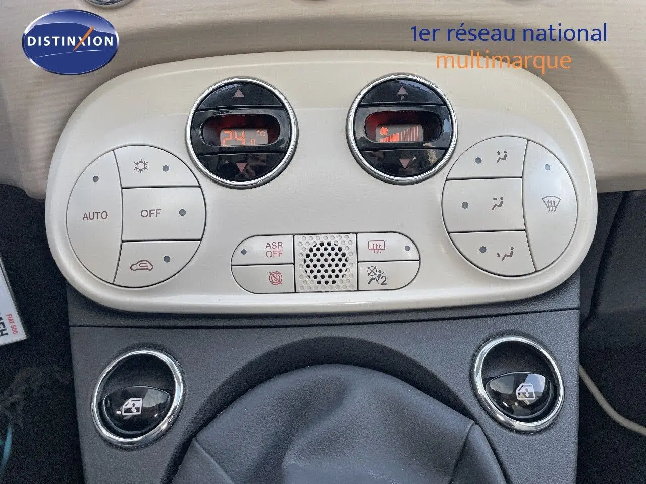 Tableau de bord de Fiat 500 blanc, vue rapprochée sur la console centrale avec commandes climatisation digitales.