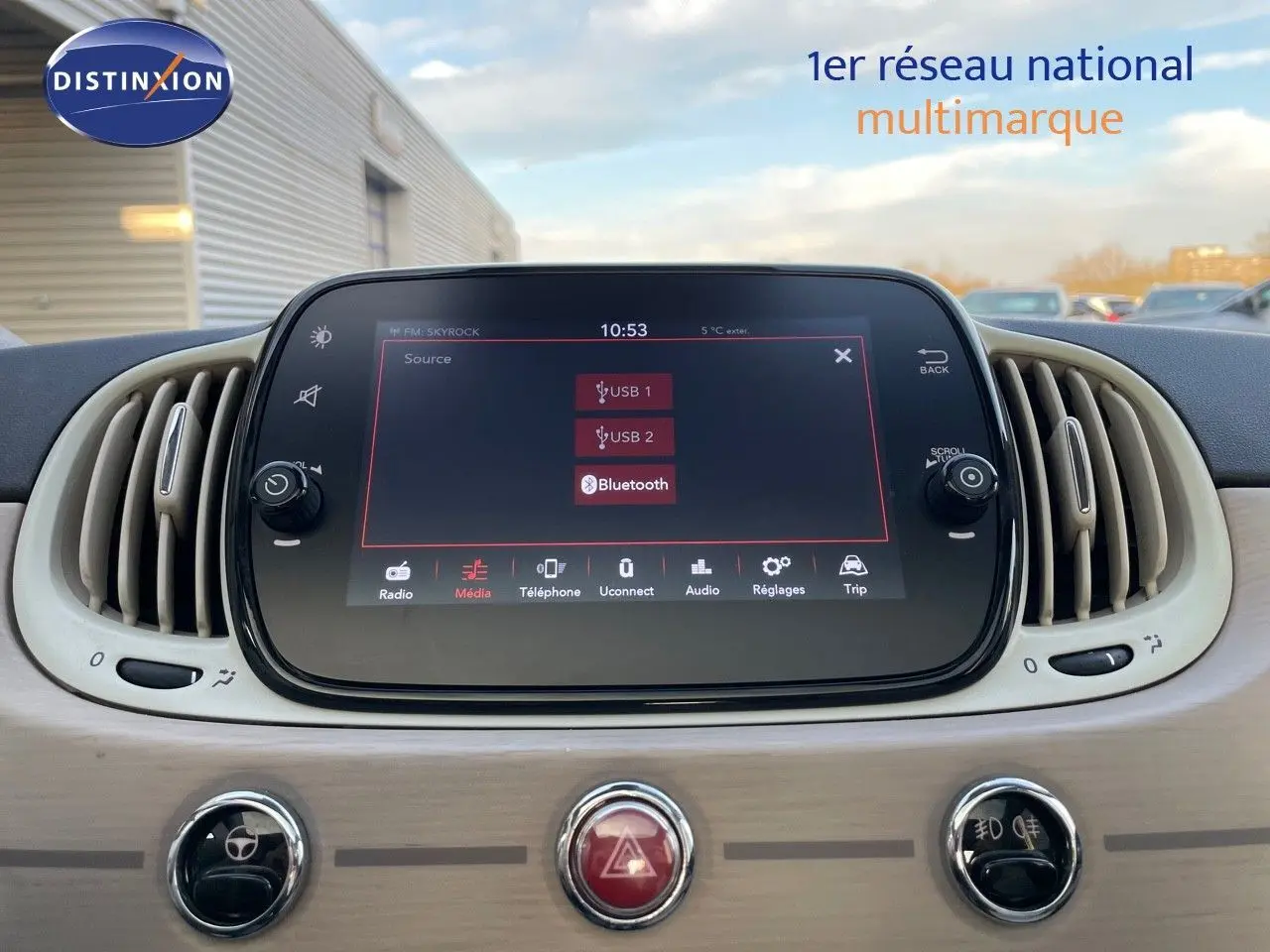 Écran tactile central affichant les options USB et Bluetooth dans l'habitacle beige clair d'une Fiat 500 blanche.