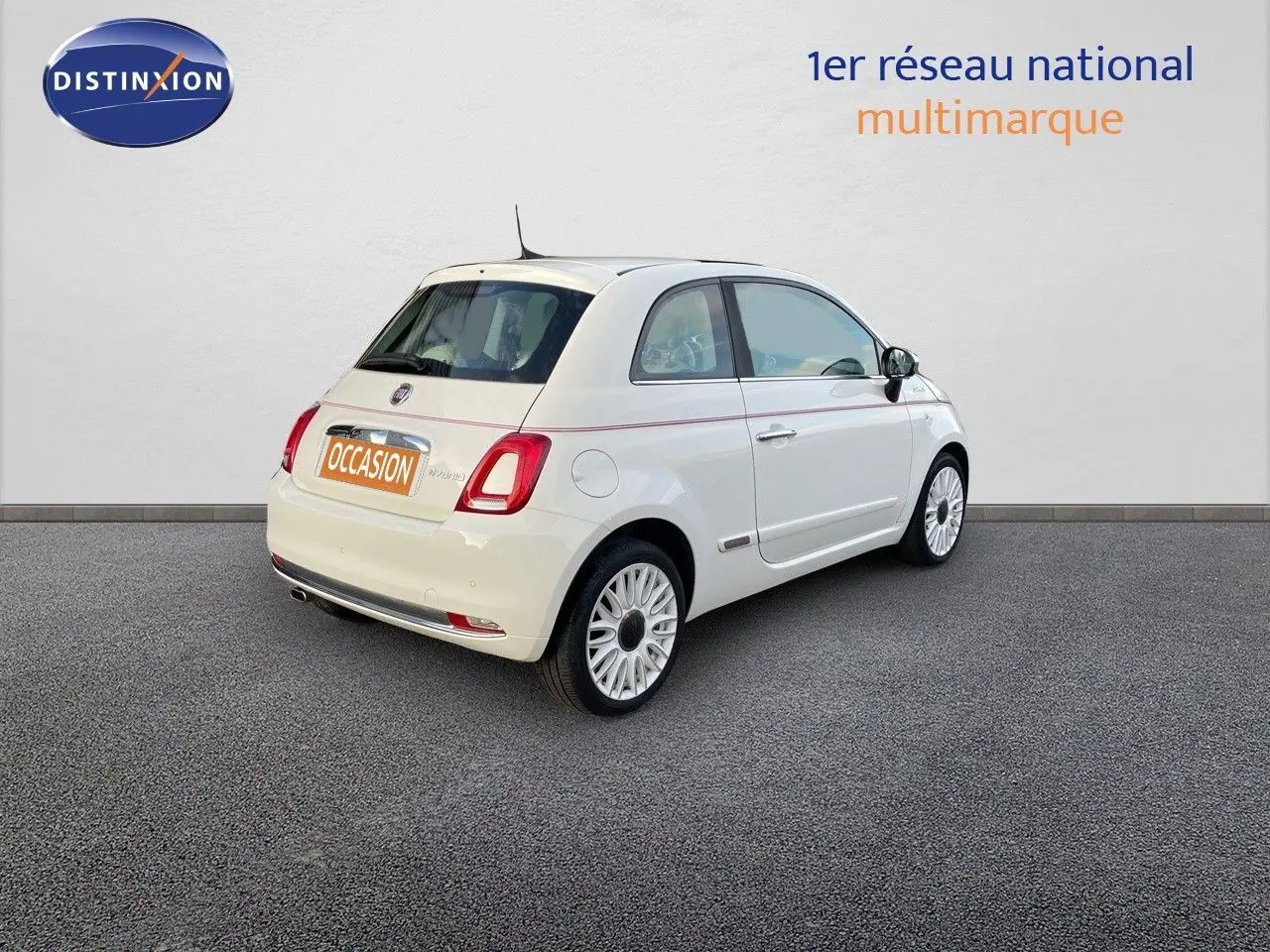 Vue 3/4 arrière droite d'une FIAT 500 blanche 2022 version 1.0 Hybrid DolceVita avec jantes biton et toit blanc.