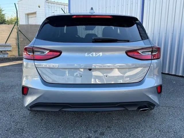 Vue arrière d'une KIA CEE'D 2024 argent lunaire avec feux LED et sortie d'échappement visible côté droit.
