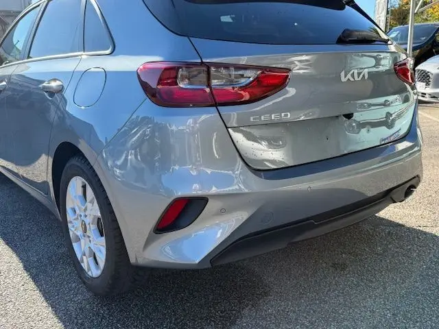 Vue arrière droite d'une KIA CEE'D 2024 argent lunaire avec feux arrière LED et logo distinctif sur hayon.