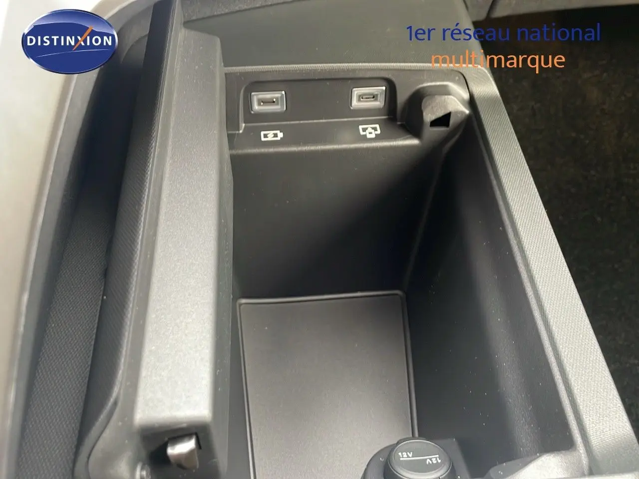Gros plan sur la console centrale du Peugeot 5008 Hybrid 136ch GT, montrant les ports USB et prise 12V.