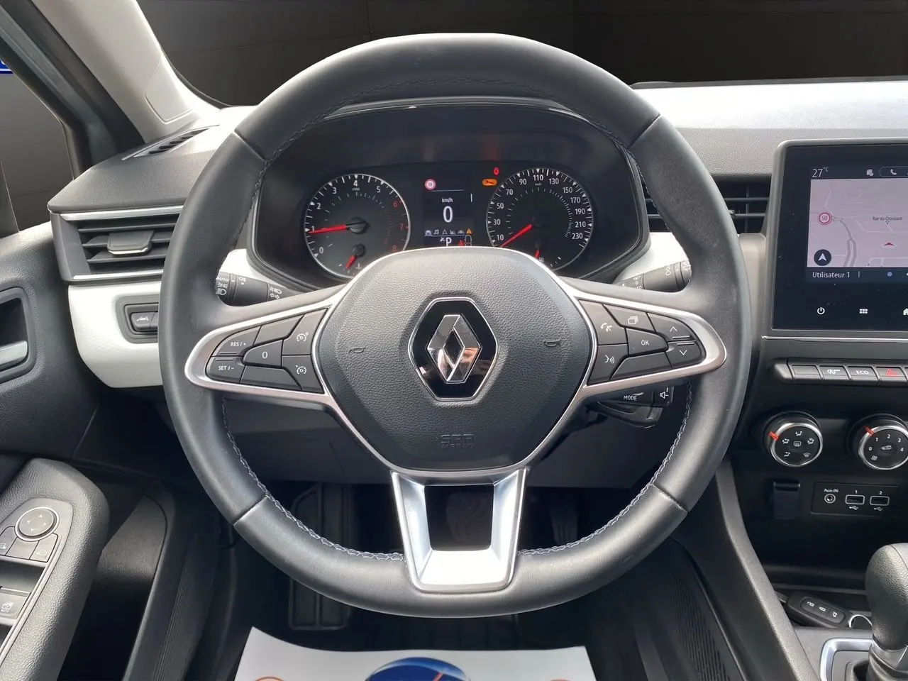 Vue frontale du volant cuir noir de la Renault Clio V TCE 90 Evolution X-Tronic avec tableau de bord et écran GPS intégré.