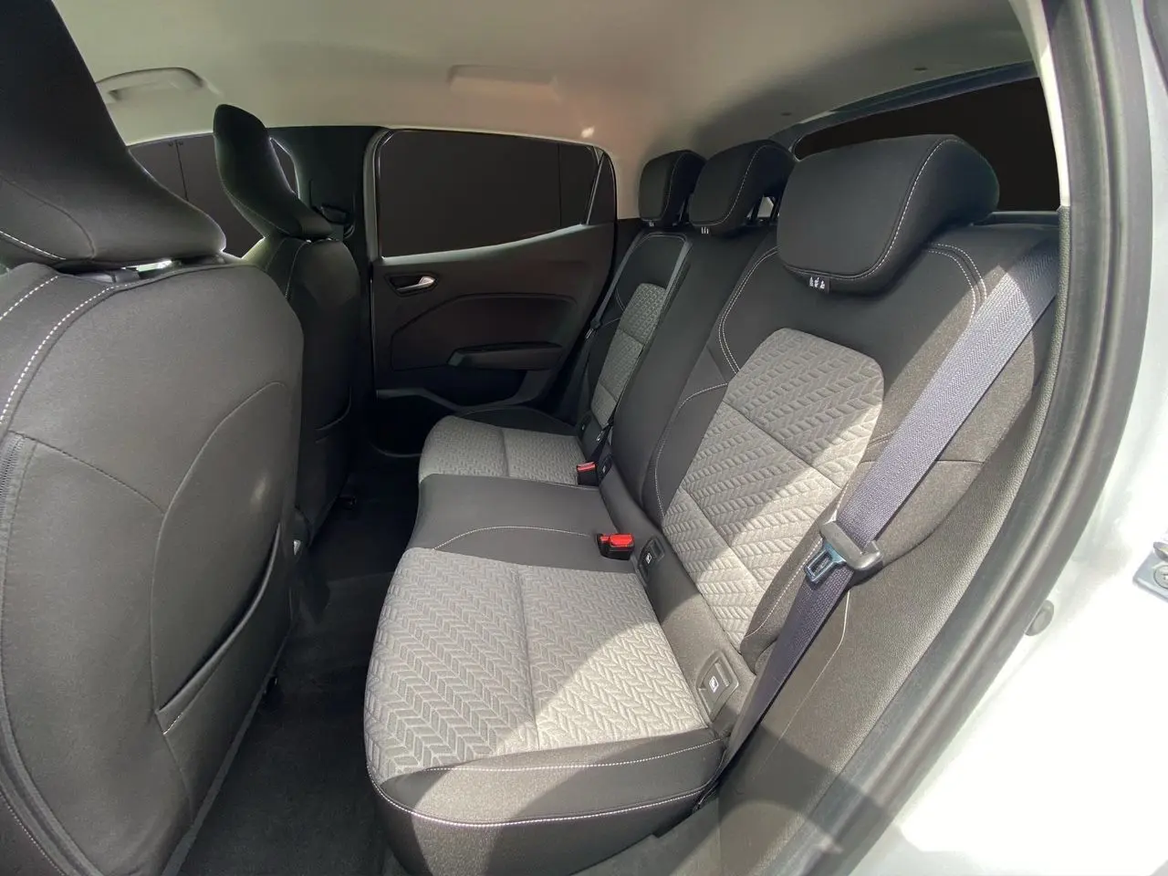 Vue intérieure arrière droite des sièges en tissu gris et noir de la Renault Clio V TCe 90 Evolution 2023