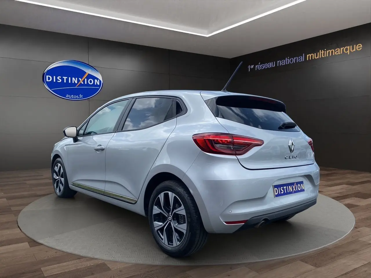 Renault Clio V TCE 90 Evolution X-Tronic gris Highland vue 3/4 arrière droit avec jantes alliage et feux LED.