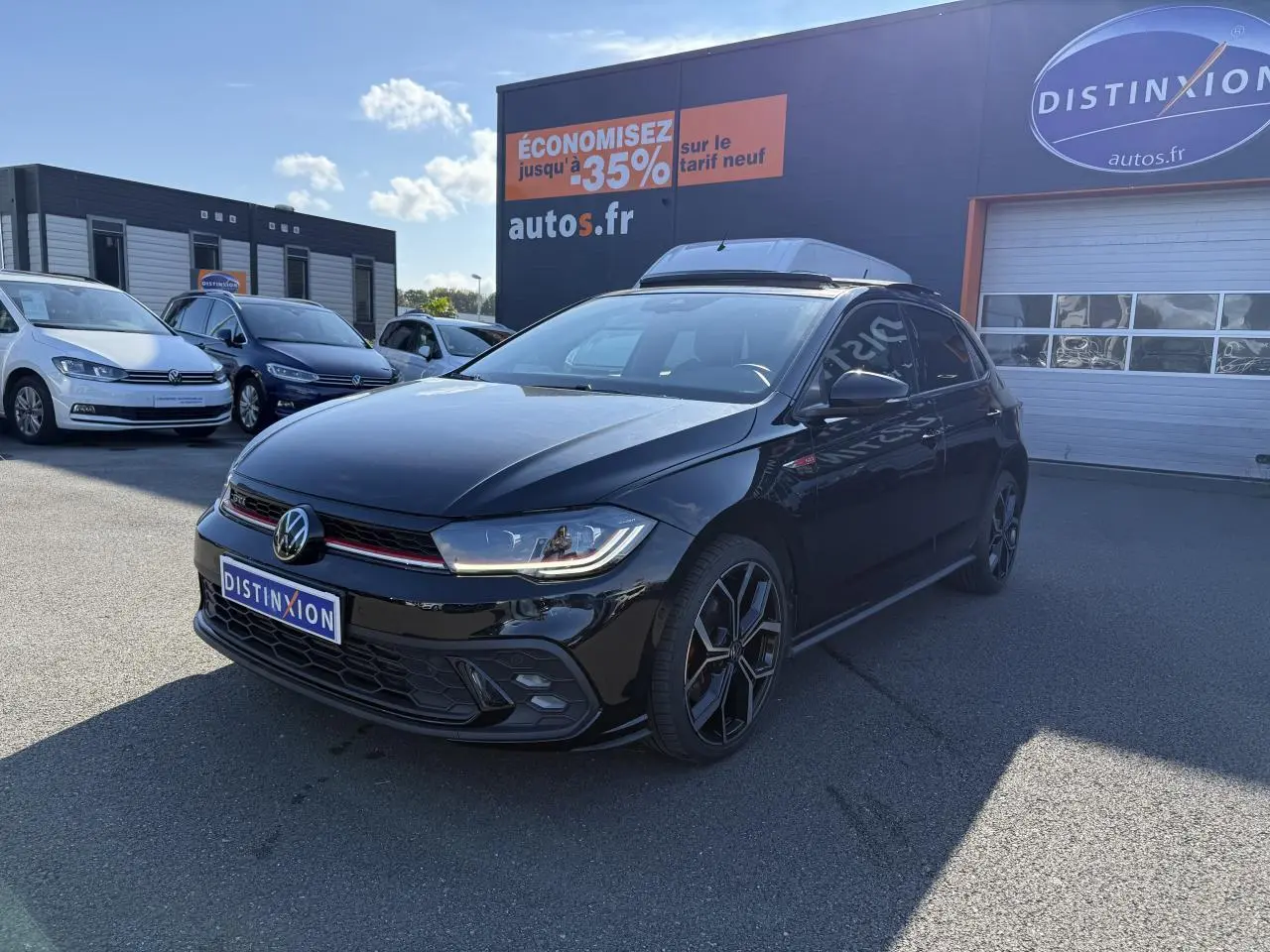 Volkswagen Polo GTI 2.0 TSI noire vue 3/4 avant droit avec jantes alliage 18 pouces et calandre GTI rouge.