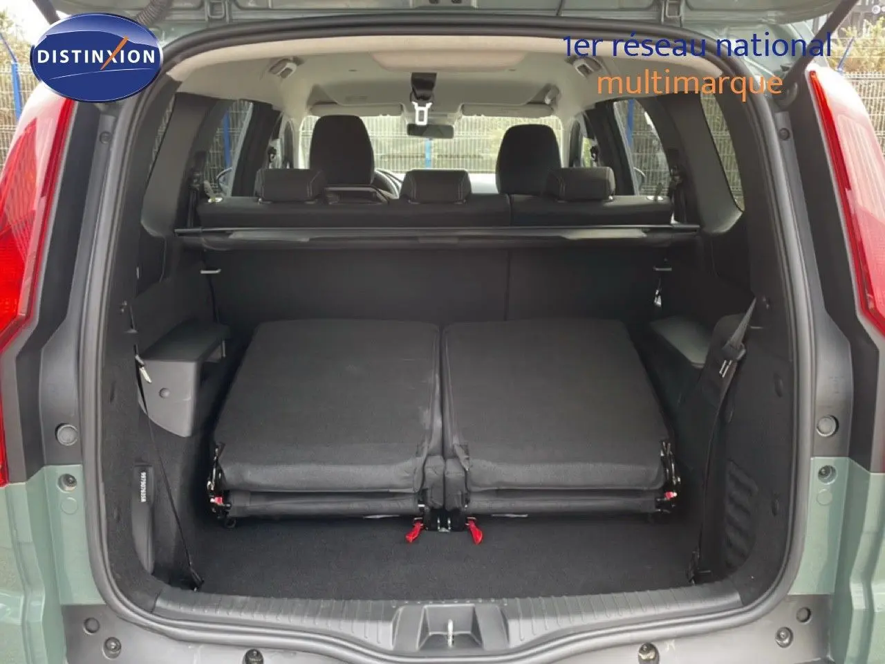 Vue arrière du coffre ouvert du Dacia Jogger kaki lichen 2025, sièges arrière rabattus et espace de chargement visible.