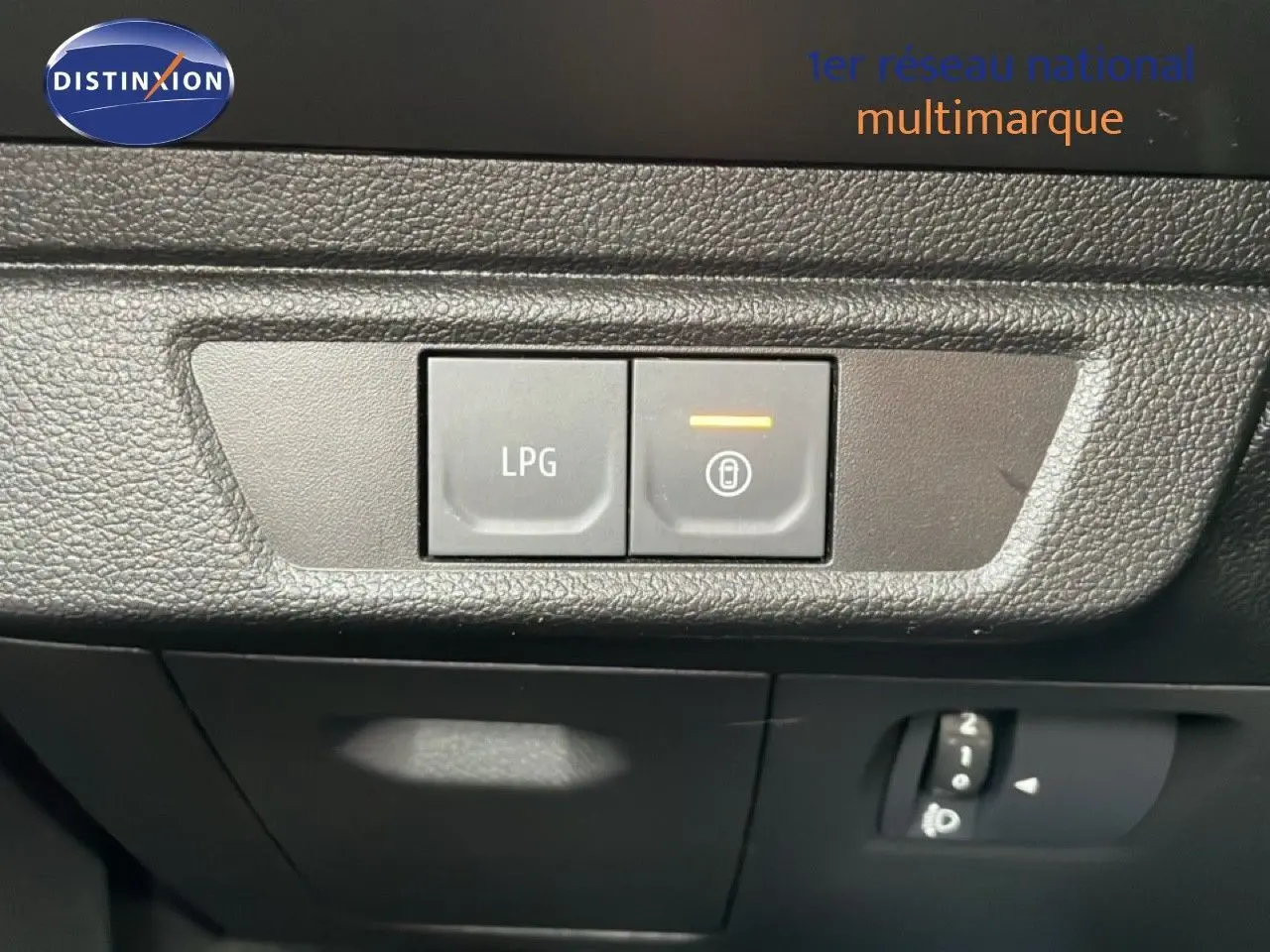 Gros plan sur les boutons de commande LPG et verrouillage intérieur du tableau de bord du Dacia Jogger kaki lichen.