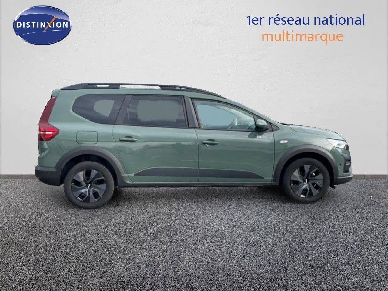 Profil droit du Dacia Jogger 2025 en kaki lichen, avec jantes noires et barres de toit visibles.