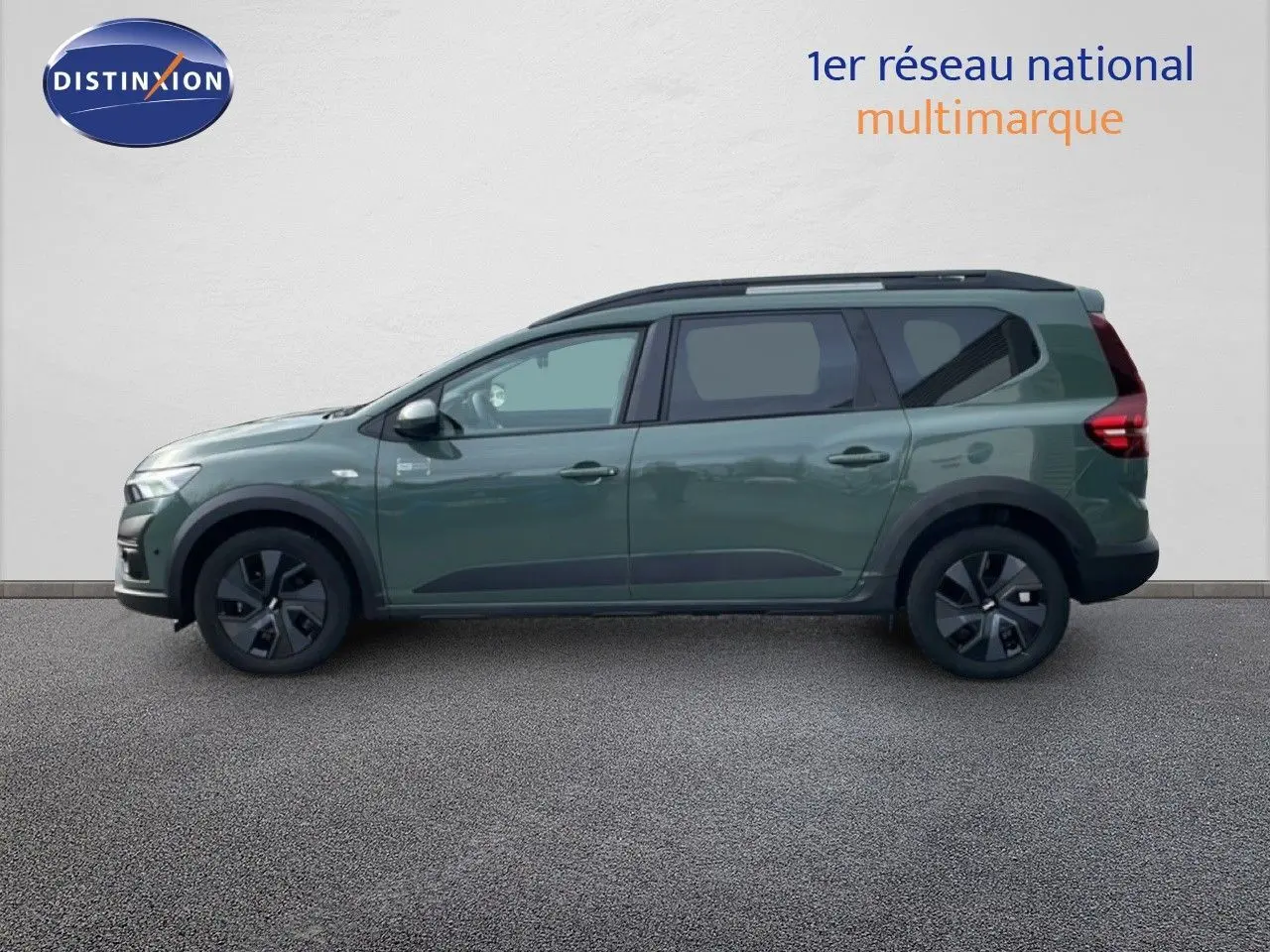 Profil droit d'un Dacia Jogger 2025 kaki lichen avec jantes noires et barres de toit visibles.