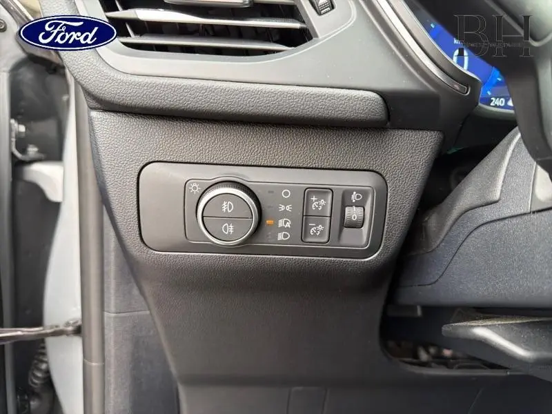 Gros plan sur les commandes d’éclairage côté gauche du tableau de bord du Ford Kuga gris Solar Métallisée 2023.