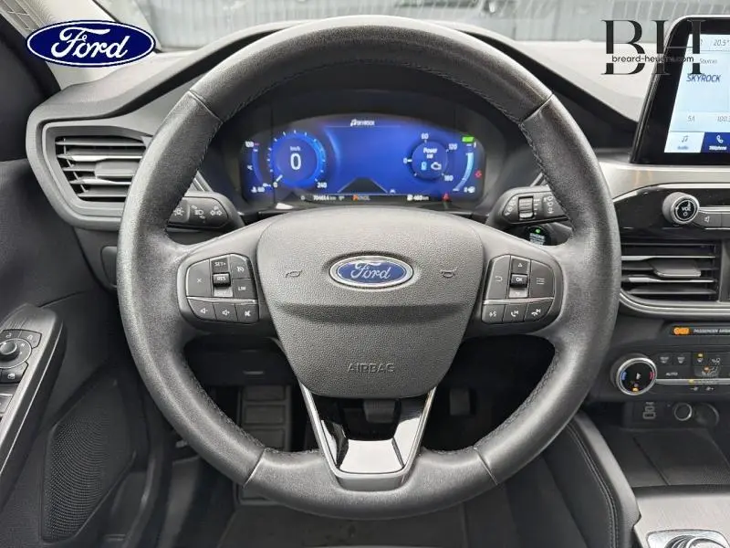 Vue frontale du volant cuir multifonction du Ford Kuga 2023 avec tableau de bord numérique et écran tactile central.