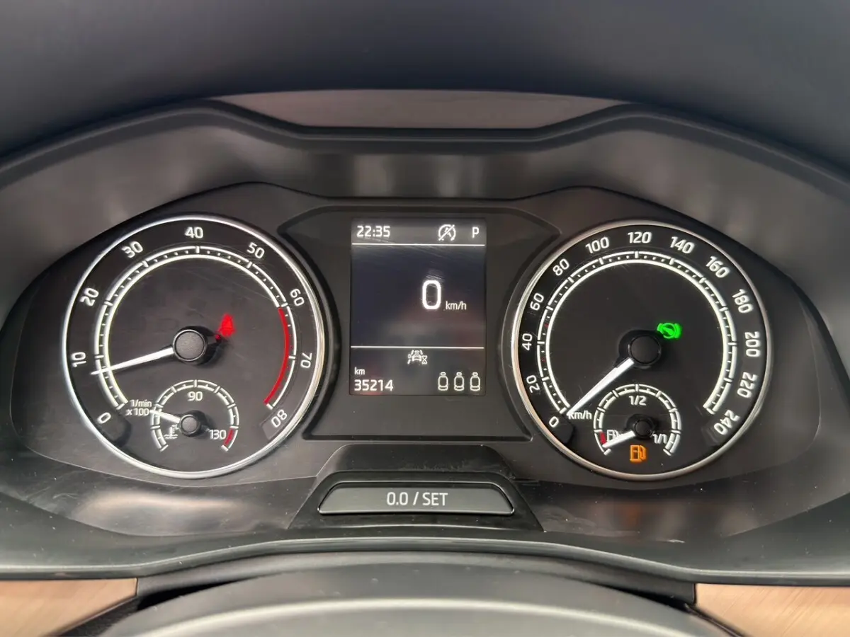 Vue centrée sur le volant cuir noir et le combiné d'instruments numérique du Skoda Kamiq 2023, tableau de bord bois clair.