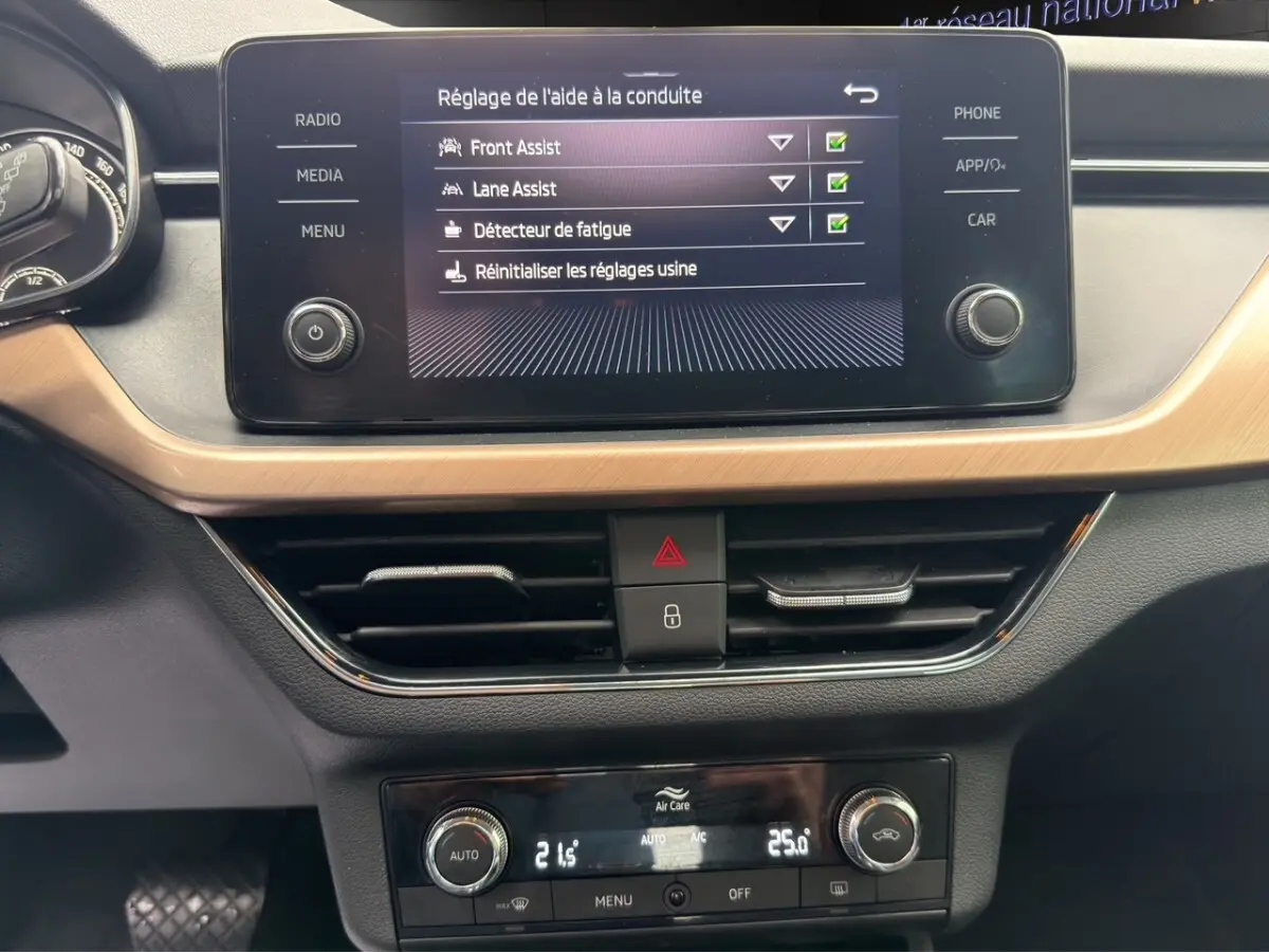 Vue intérieure du tableau de bord et console centrale du Skoda Kamiq 2023 avec écran tactile affichant la caméra de recul.