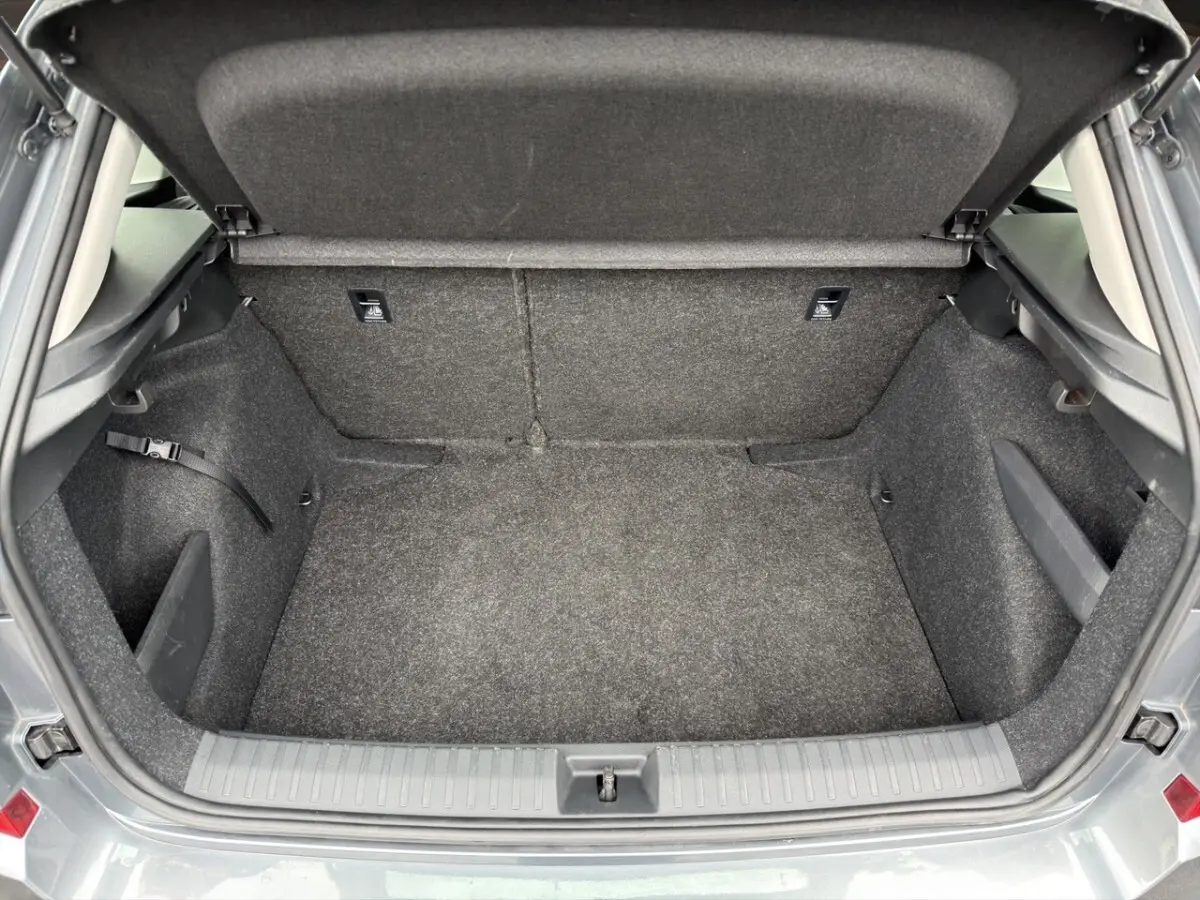 Vue intérieure arrière côté gauche du Skoda Kamiq gris foncé, sièges tissu bi-ton avec surpiqûres orange.