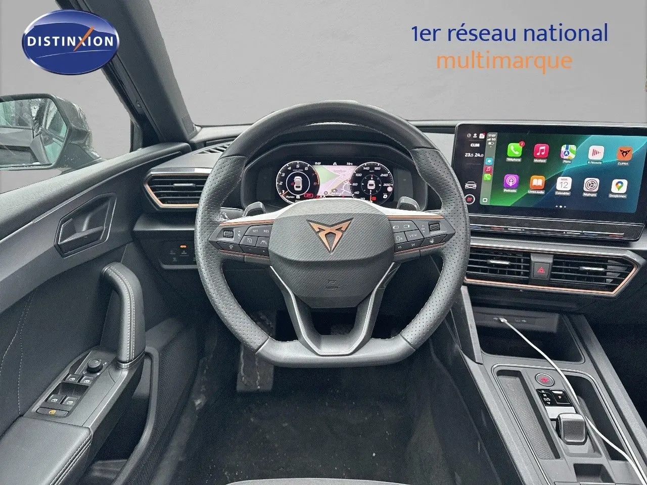 Vue intérieure du poste de conduite de la CUPRA LEON ST noir, avec volant multifonction et écran tactile central lumineux.