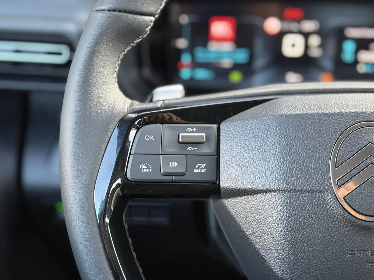 Gros plan sur la partie gauche du volant cuir noir du Citroën Berlingo Multispace 2025 avec commandes multifonctions.