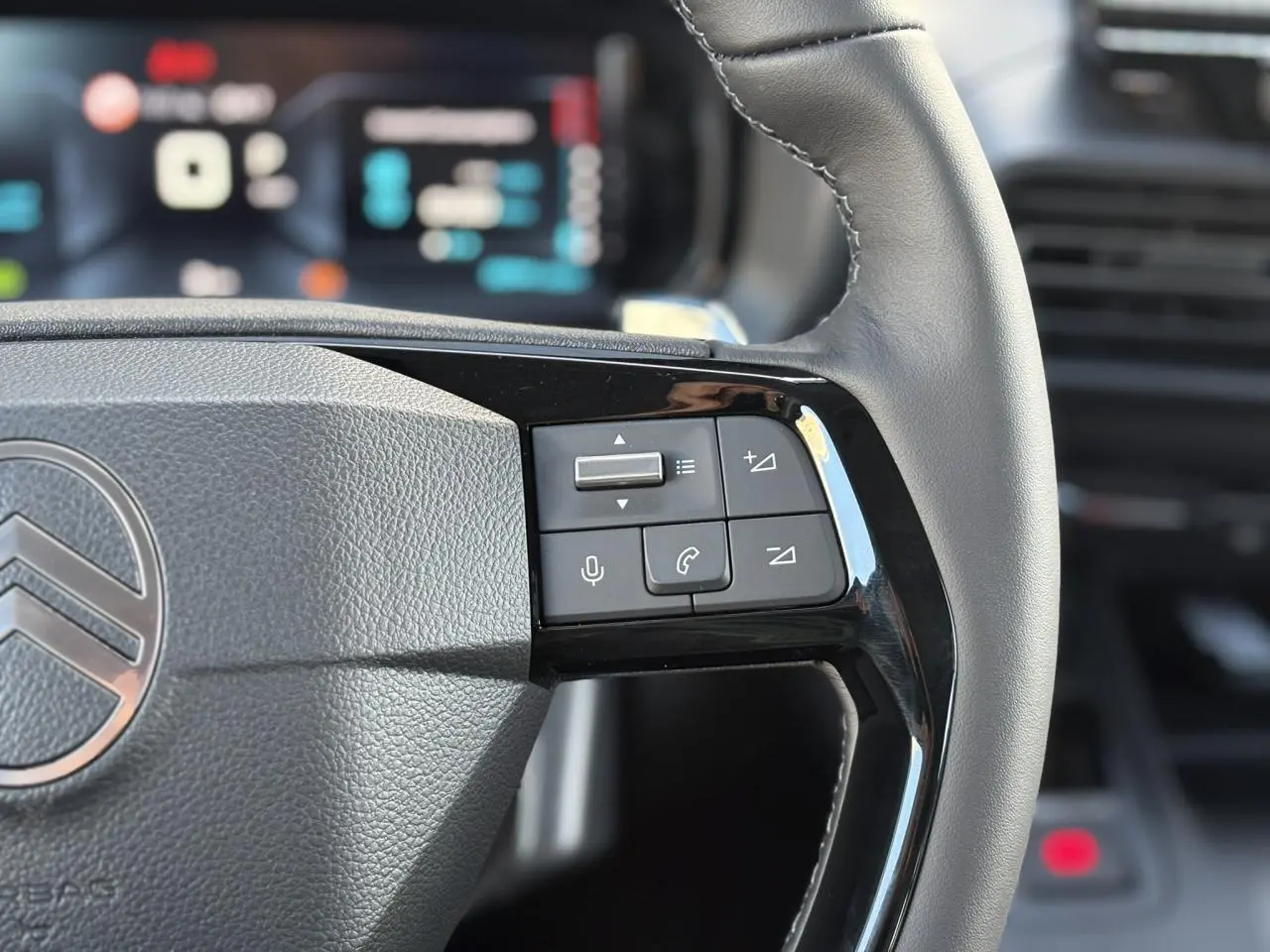 Gros plan sur le volant en cuir multifonctions du Citroën Berlingo Multispace 2025, avec commandes audio et téléphone.