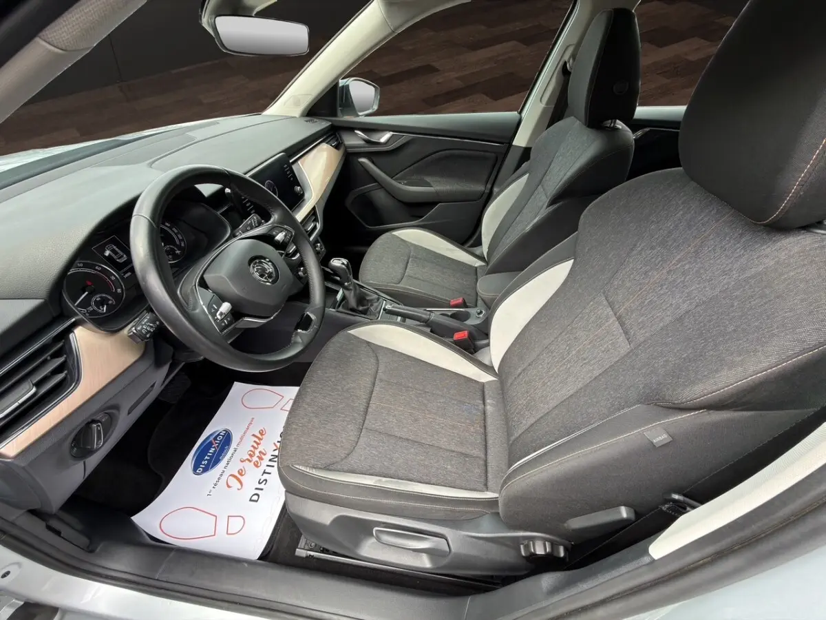 Gros plan sur la jante bi-ton noire et argentée du côté avant droit d'un Skoda Kamiq gris clair.